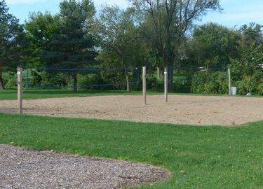 Large sand volleyball court with two nets set up at Evans Park