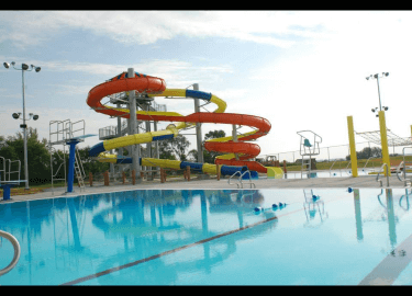 Large pool and yellow and orange winding waterslides