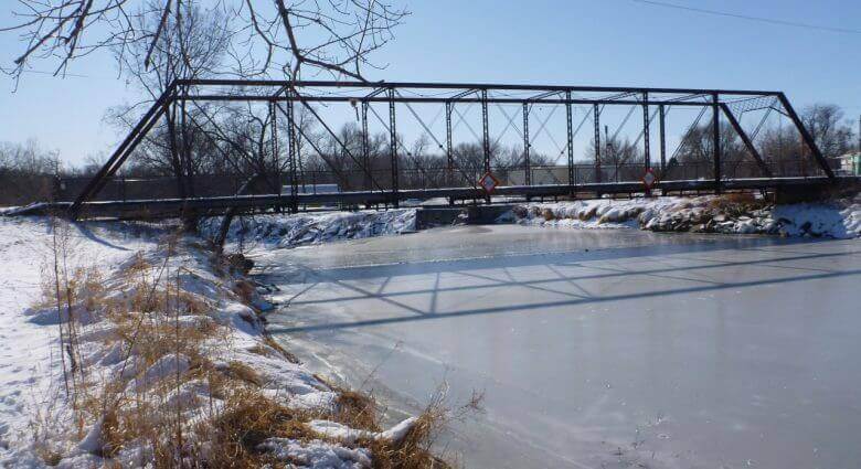 Large steel bridge suspended on an iced over body of water